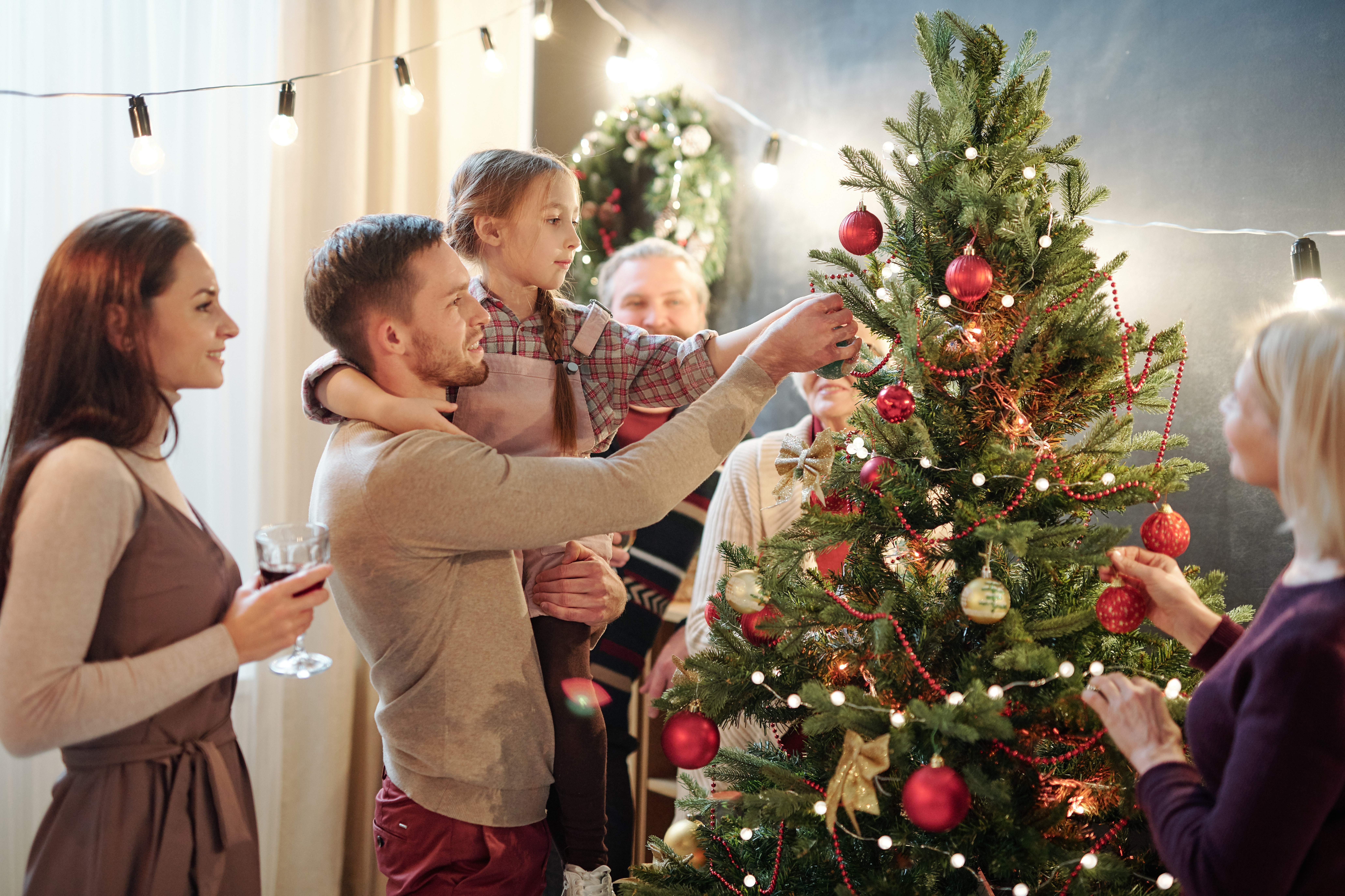 Šťastná rodina zdobí vianočný strom.